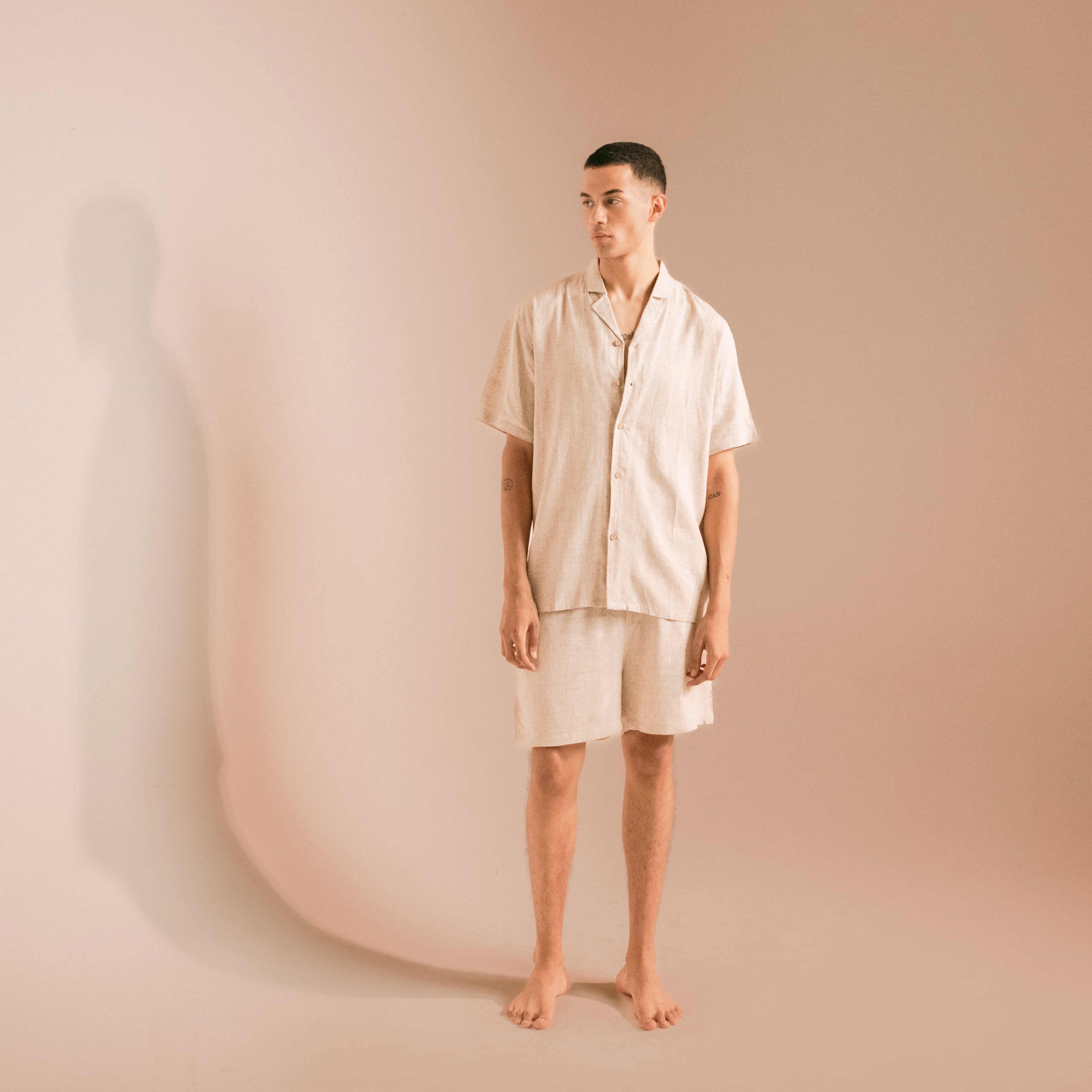 Man wearing a beige pajama set against a plain background