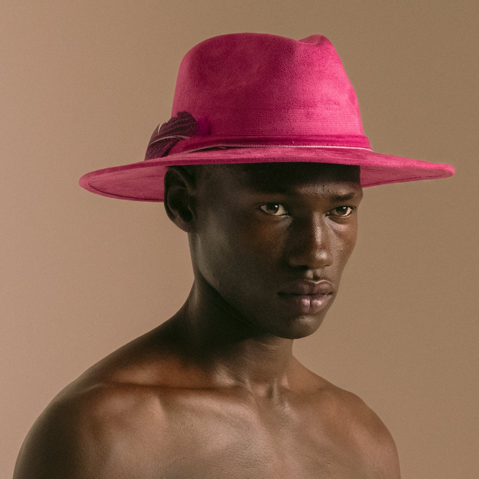 Man wearing a pink hat against a beige background