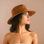 Woman wearing a brown hat against a beige background