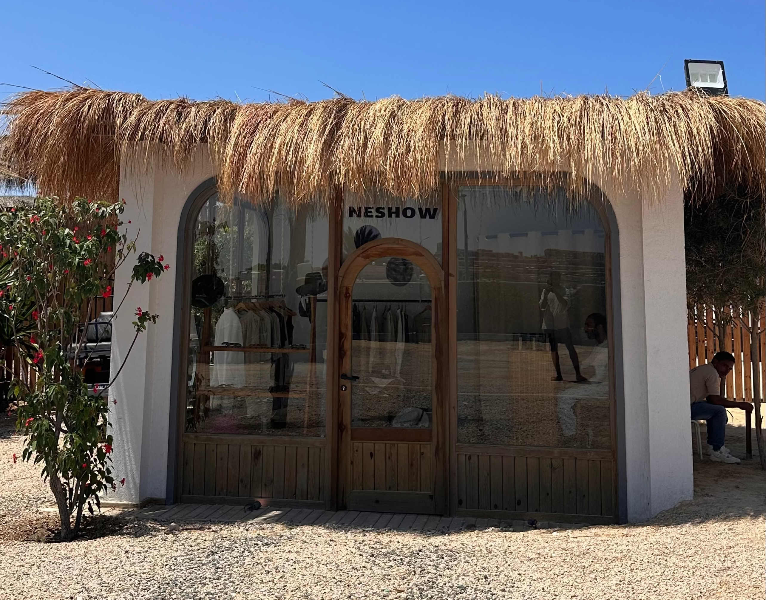 Small building with a thatched roof under a clear blue sky