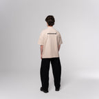 Male Model wearing a beige shirt with NESHOW logo on the back against a white background