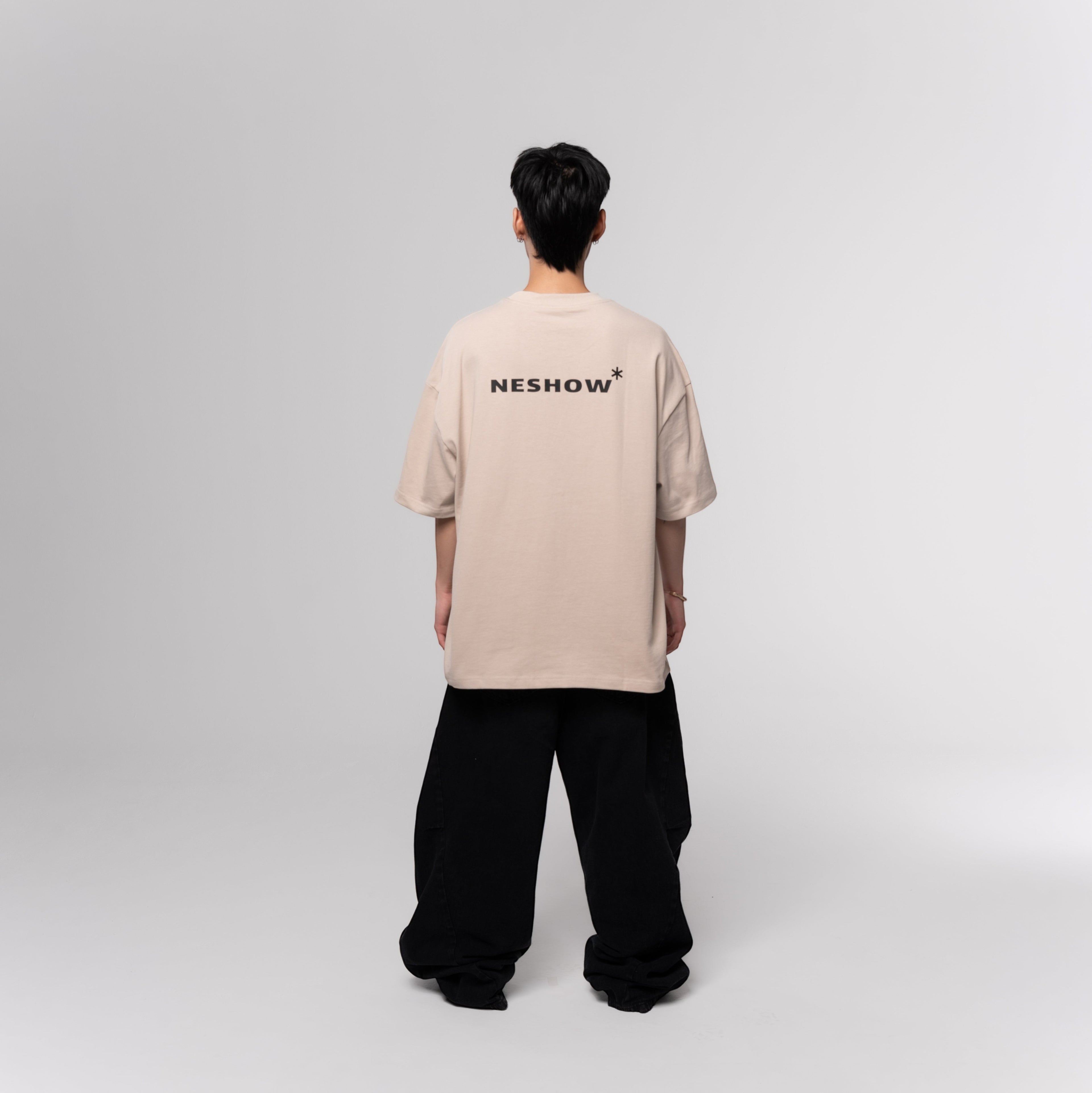 NESHOW beige oversized 320gsm sustainable cotton t-shirt with black logo on back and random number print on front.